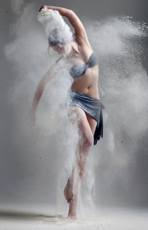 Studio portrait of woman dancing with flourの写真素材