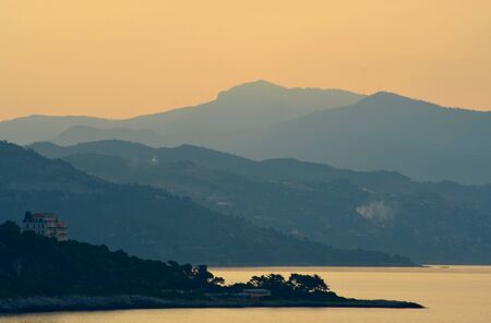 Sunrise over the hills of the Mediterranean. A white house is in the foregroundの写真素材