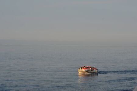 A tender boat crusing on an empty sea.の写真素材