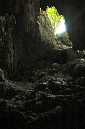 A shaft of sunlight lightens an underground caveの写真素材