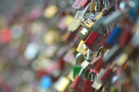 Hundreds of padlocks on a love-lock bridge. Only the padlocks are visible. Only a few are in focus...