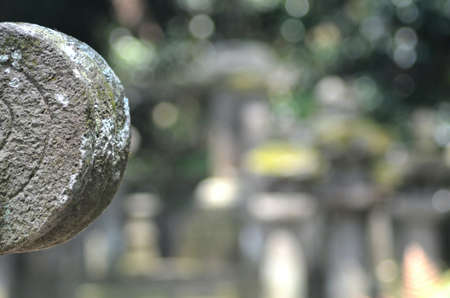 The round stone edging of a shrine in a Japanese temple is carved with concentric circles. The stone...