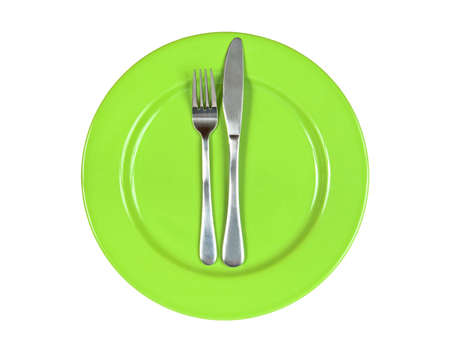 Fork and knife on green plate isolated on whiteの写真素材
