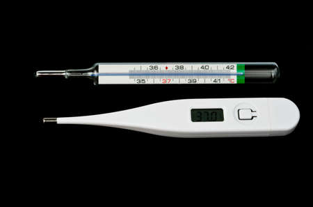 Digital and analogue thermometers over black