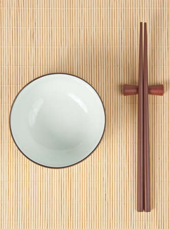 Chopsticks and bow for rice on bamboo coverの写真素材