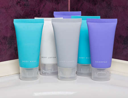 Body lotion, shampoo and conditioner in tubes in bathroomの写真素材