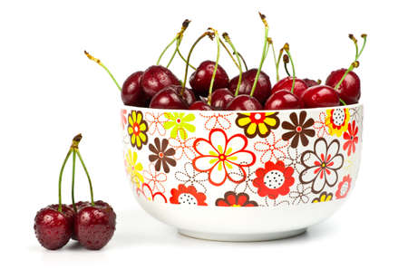 Bowl with ripe sweet cherries isolated on white.の写真素材