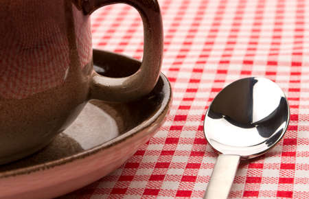 Tea spoon and cup with saucer close up