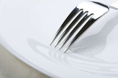Fork on white plate close upの写真素材