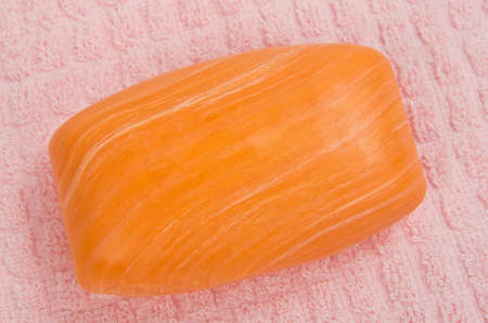 Orange glycerin soap bar over pink towelの写真素材