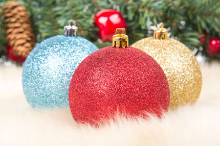 Christmas balls on fur with christmas decoration on backgroundの写真素材
