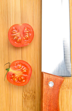 Kitchen knife and tomatoes on chopping boardの写真素材