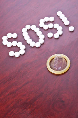 Prevention of indesirable pregnancy concept with condom and text SOS の写真素材