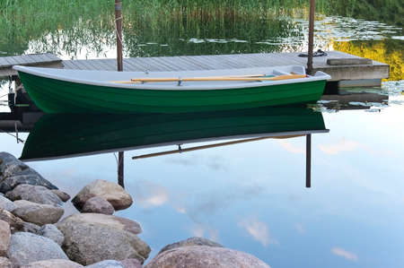 Row boat near wooden jetty. Upside down picture.の写真素材