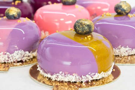 Mousse cake with mirror glaze and blackberry decoration close up