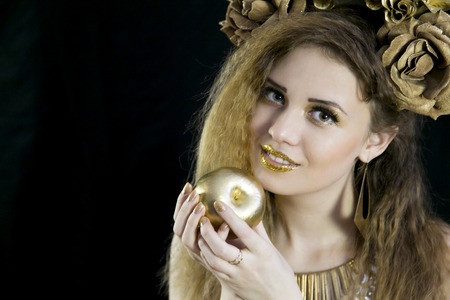 A girl like the Statue of Liberty with a crown on her head and a golden appleの写真素材