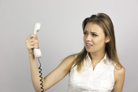 Emotion girl when talking on the phone. The girl is talking on the phone while on the face different emotions - joy, anger, fright, stress, hatred, anger, tension, fearの写真素材