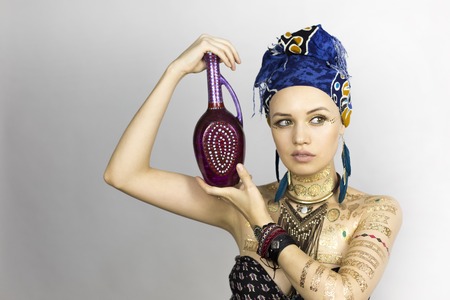Girl with jug. A beautiful girl in African style clothes is holding a pitcherの写真素材
