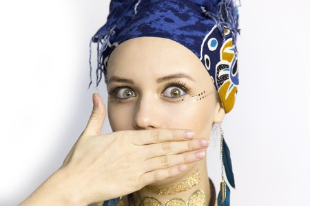 The girl is covered with her hand. A girl in African style clothes with different emotions on her faceの写真素材