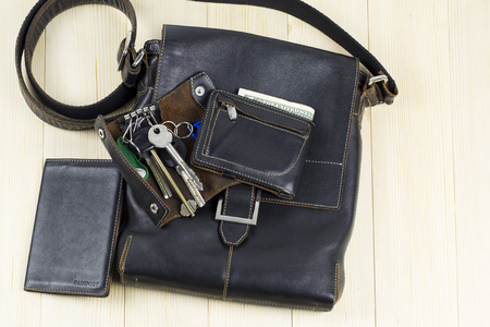Leather goods for men. A set of men's leather accessories, a bag, a passport cover, a wallet, a handbag, a keychain case on a light backgroundの写真素材