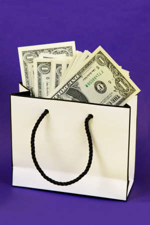 Gift bag with money. Paper money in a beautiful gift box on a bright violet blue background