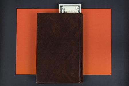 Paper money in the book. The dollar denomination is used as a bookmark of the pages in the bookの写真素材