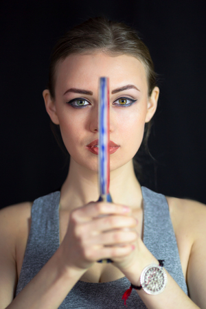 The athlete divides the face into two parts by a tennis racket. A beautiful girl holding a table tennis racket in front of her face and divides her face.の写真素材