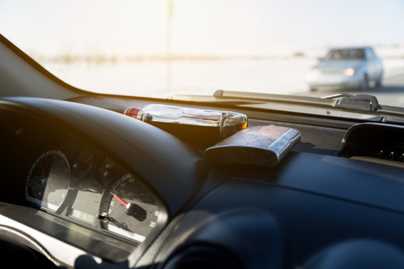 Alcoholic drinks lie near the windshield of the car. The dashboard of the car is liqueur and cognac.の写真素材