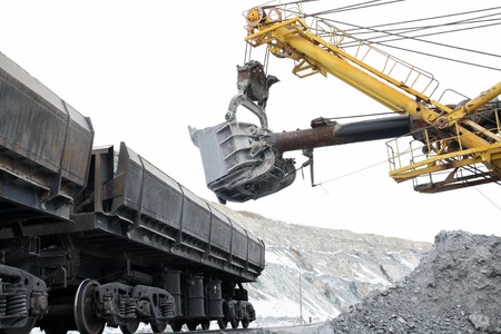 The excavator loads the stones into the cars. Loading ore in the railway cars in the quarry.の写真素材