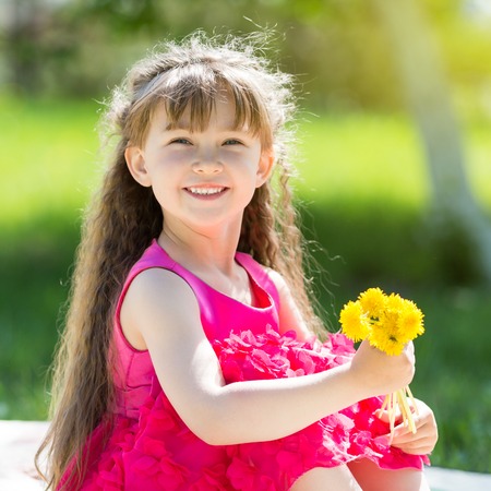 A little girl is holding a bouquet of flowers.の写真素材