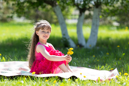 A little girl is holding a bouquet of flowers.の写真素材