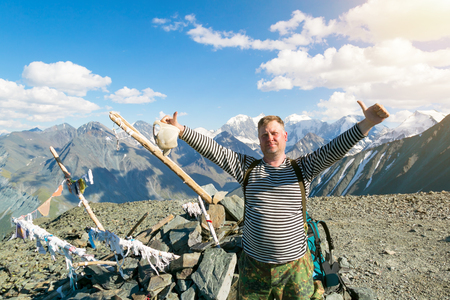 A tourist waving his hand in greeting. Male traveler 45-50 years old happily waving his hand in the mountains.の写真素材