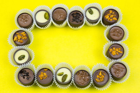 Frame of chocolates. Place your text on the colored background.の写真素材