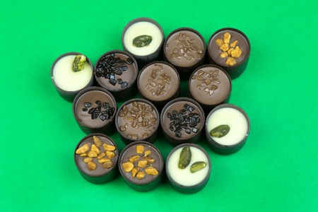 Chocolate candies on a colored background. Candies with different fillings laid out on a color...