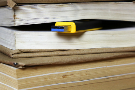 Concept flash memory replacement book. 64 gigabyte memory card among the pages of a paper book.