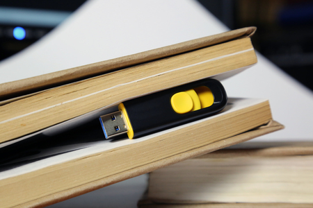 Concept flash memory replacement book. 64 gigabyte memory card among the pages of a paper book.