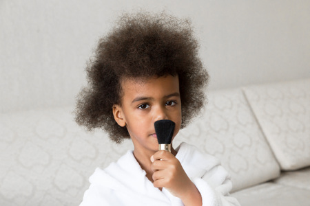 Black girl caring for the skin. Afro-American child make upの写真素材
