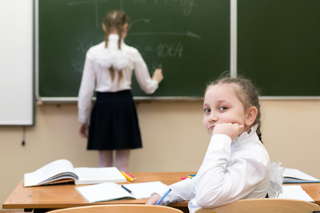 Schoolgirl looks at the blackboard. schoolgirl girl looks at the blackboard.の写真素材