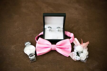 Personal belongings of the groom on the wedding day. Unfolded things groom watches, cufflinks,...