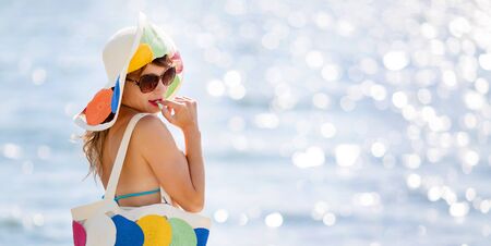Elegant slim girl by the sea young slim woman with a beautiful figure in a hat is standing on the...