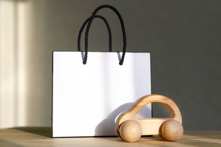 A small car model made of wood next to gift box concept car as a gift.の写真素材