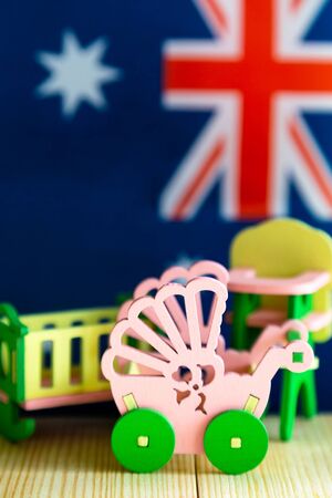 Maternity and childbirth in the Australia. Fertility and population growth in the United Kingdom, children's furniture against the backdrop of the flag of Australiaの写真素材