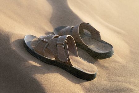 Men's sandals in a sandstorm. Men's summer shoes brought in sand in the desertの写真素材
