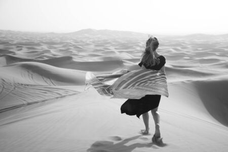Photoshoot of a caucasian girl in the desert. Black and white imageの写真素材