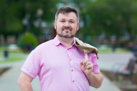 Handsome adult Caucasian male in pink clothes. Portrait of a lonely adult man with a beard for a profile on a dating site.の写真素材