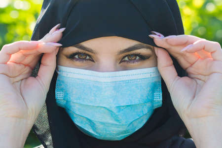 Oriental woman in black clothes in a protective medical mask. Oriental woman in black clothes in a...