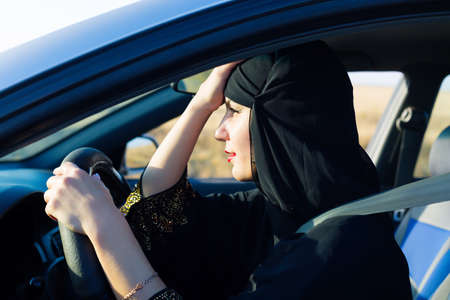 Tired islamic woman in traffic jam sitting behind the wheel.の写真素材