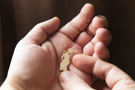 Silhouette figure a pregnant woman lies on a man's hand