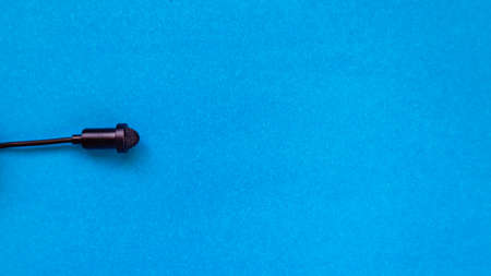 Small size audio microphone on a blue background. Copy space.の写真素材