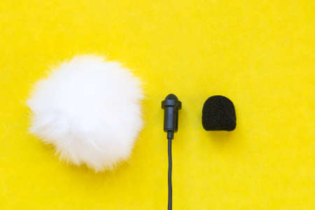 Lavalier small microphone and wind protection on yellow background.の写真素材